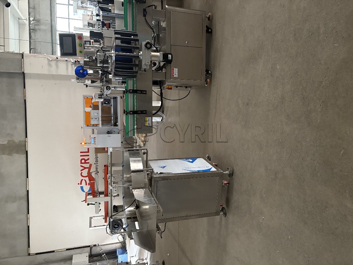 10-head servo-driven filling machine with enclosure, 4-wheel capping, star-wheel labeling, and bottle unscrambling/collection.
