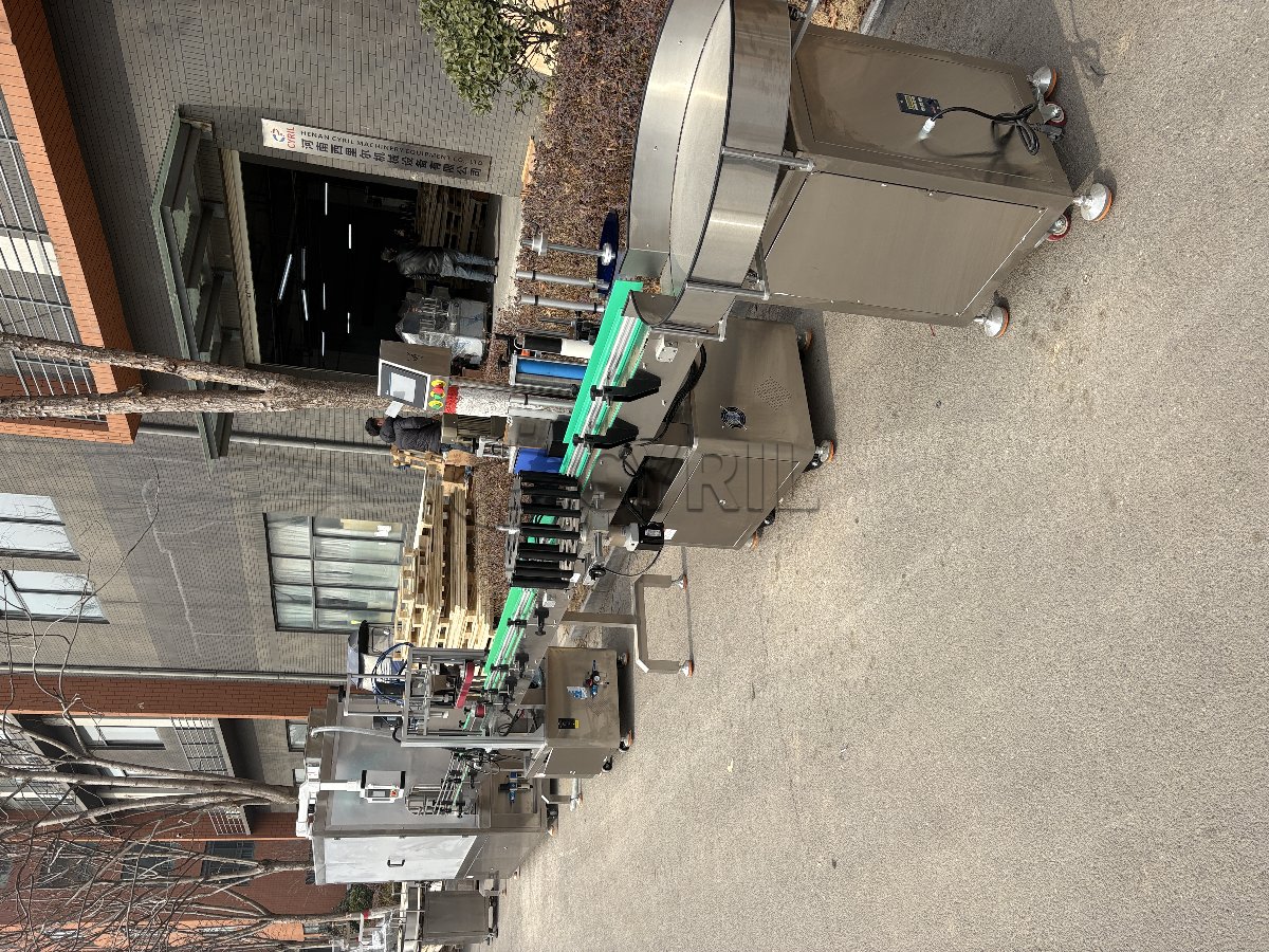 10-head servo-driven filling machine with enclosure, 4-wheel capping, star-wheel labeling, and bottle unscrambling/collection.